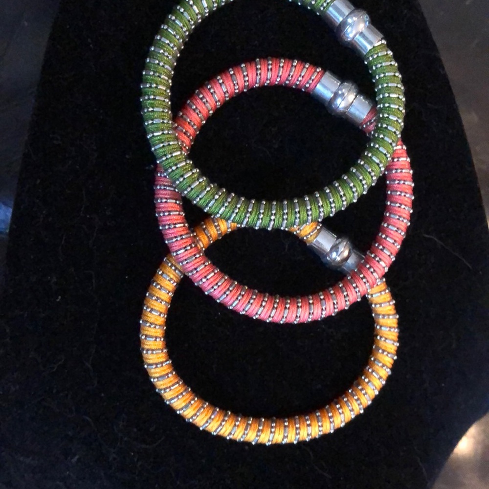 Three bracelets -  pink green and yellow.  Clasp closure.